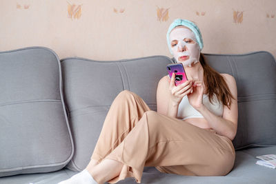 Midsection of woman sitting on sofa at home