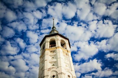 Low angle view of bell tower against clouds