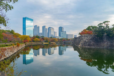 Reflection of buildings in lake against sky