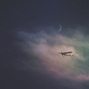 Low angle view of silhouette airplane flying against sky