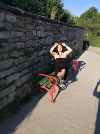 Full length portrait of young woman on wall