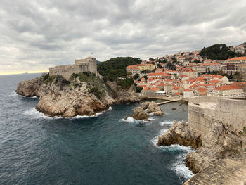 Buildings by sea against sky in city