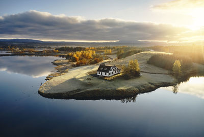 Farm house near lake during sunset