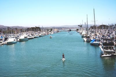 Yachts moored at harbor against clear sky