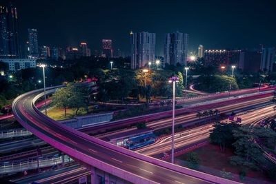 High angle view of light trails on road amidst buildings in city