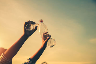 Low angle view of woman hand against sky during sunset