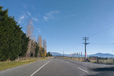 Road by trees against sky