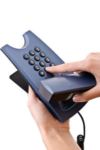 Close-up of hand holding camera over white background