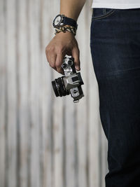 Midsection of man holding camera