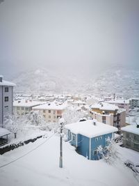 High angle view of snow covered houses and buildings against sky