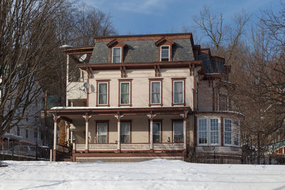 House on field against sky during winter