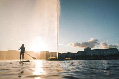 Silhouette man standing by sea against sky