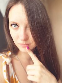 Close-up portrait of beautiful woman with hand on chin