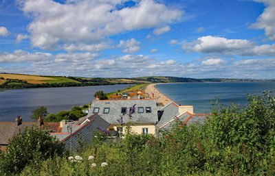 High angle view of houses by sea against sky