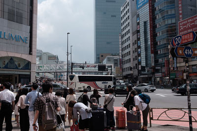 People on street in city against sky