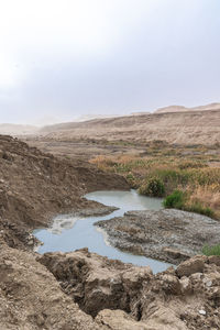 Sinkhole filled with turquoise water, near dead sea coastline. hole formed when underground salt is