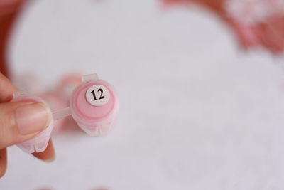 Close-up of hand holding pink ring