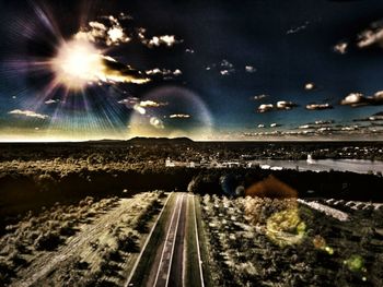 Illuminated railroad tracks against sky at night