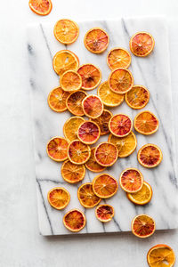 A marble slab topped with spiced dried orange slices.