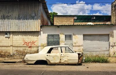 View of old abandoned car in city