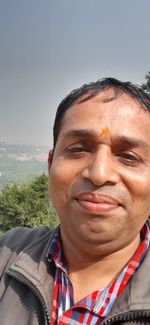 Close-up portrait of man wearing sunglasses against sky