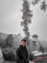 Portrait of young man standing against sky during winter