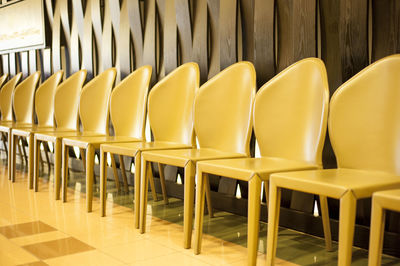 Empty yellow chairs arranged in row