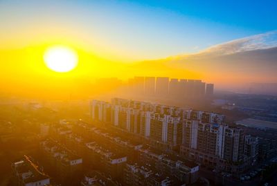 High angle view of modern buildings against sky during sunset