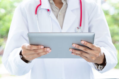 Midsection of man using mobile phone