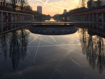 Bridge over river in city during sunset