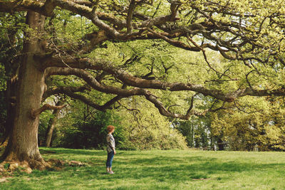 Full length of woman standing by tree at park