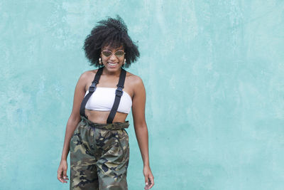 Smiling woman standing against wall