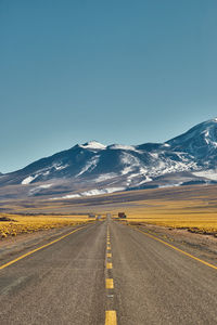 Road leading towards mountain against sky