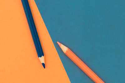 High angle view of colored pencils against blue background