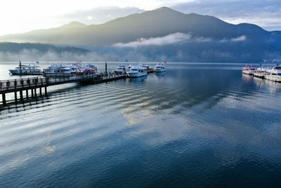 Yachts moored at harbor in lake