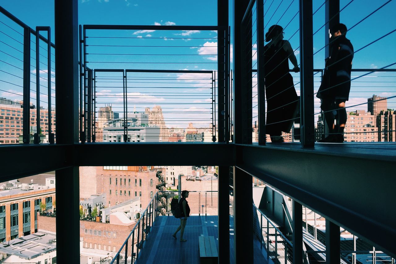 architecture, built structure, glass - material, building exterior, men, indoors, window, city, transparent, lifestyles, railroad station, person, sky, city life, incidental people, day, leisure activity, railing