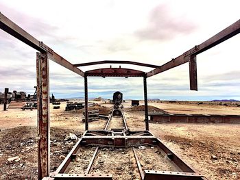 Man standing by railroad tracks against sky