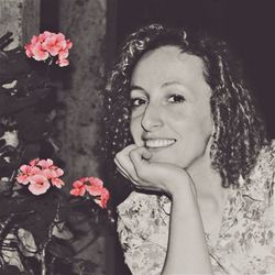Portrait of a smiling young woman by flowering plants