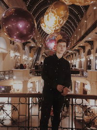 Portrait of a young man looking at balloons