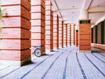 Bicycle parked near column at corridor