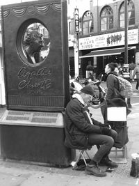 People sitting on seat in city