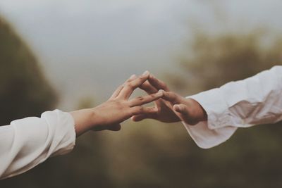 Midsection of couple holding hands