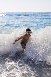 Man surfing on sea against sky