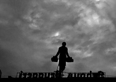 Low angle view of silhouette man against sky