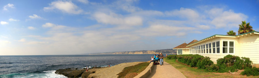 People on beach by sea against sky