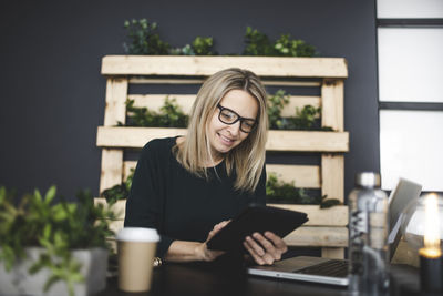 Young woman using mobile phone while sitting outdoors