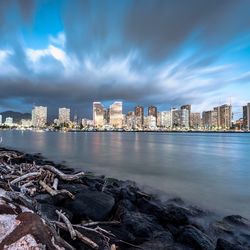 View of cityscape against cloudy sky