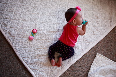High angle view of baby girl with pacifier at home