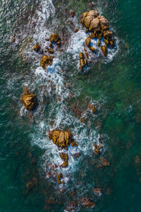 Aerial view of rocks in sea