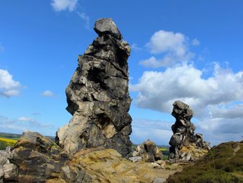 Low angle view of rocks against blue sky